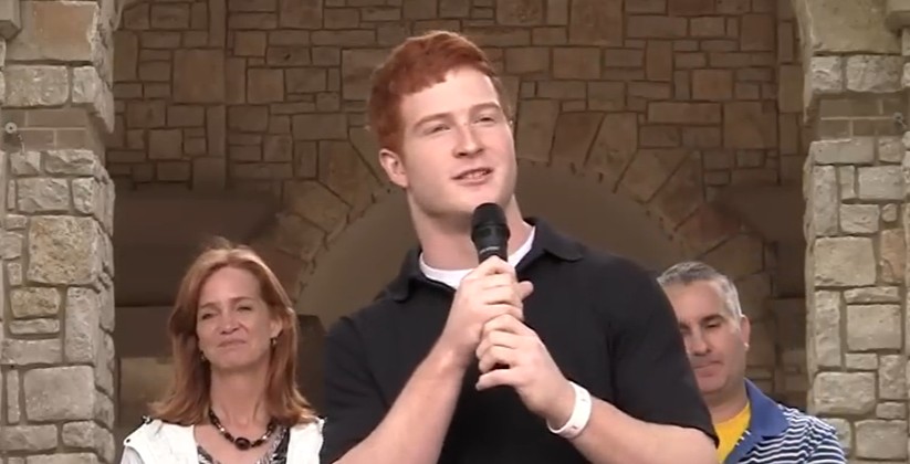 Patrick speaking into a microphone at a gathering